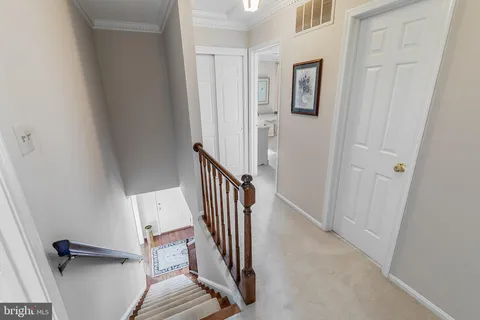 a view of a hallway with wooden floor and staircase
