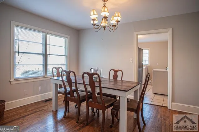 a view of a dining room with furniture a chandelier and wooden floor