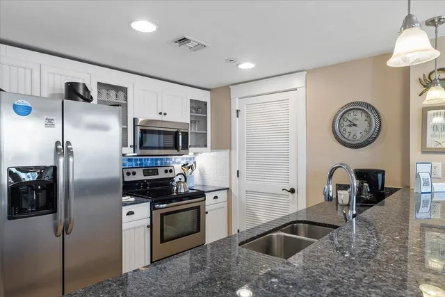 a kitchen with stainless steel appliances granite countertop a stove a refrigerator and a microwave