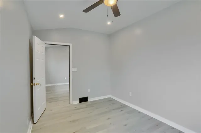 an empty room with closet and a chandelier fan
