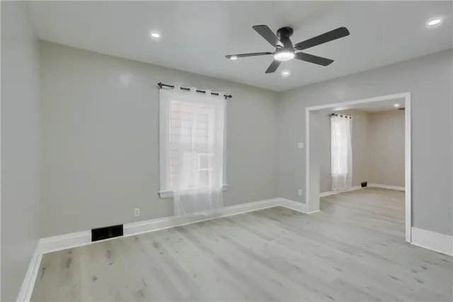 wooden floor in an empty room with a ceiling fan