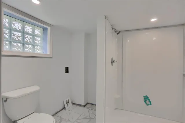 a bathroom with a toilet and a shower