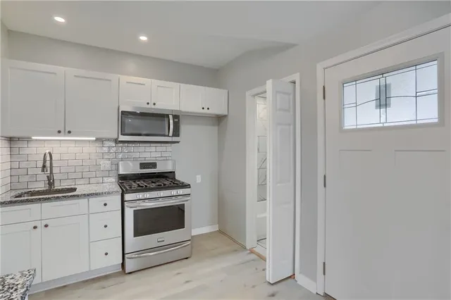 a kitchen with white cabinets and white appliances