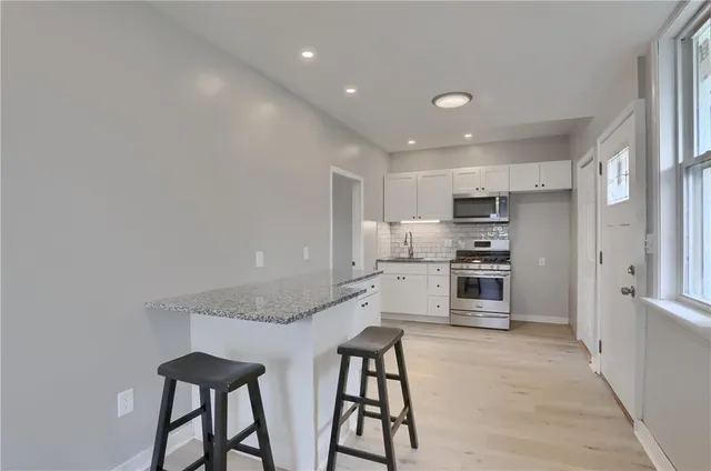 a kitchen with stainless steel appliances kitchen island granite countertop a refrigerator and stove top oven