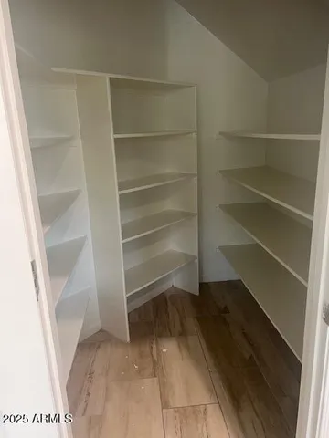 a view of walk in closet with empty racks