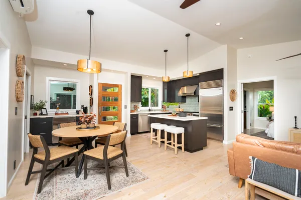 a kitchen with stainless steel appliances kitchen island granite countertop a table chairs and a stove