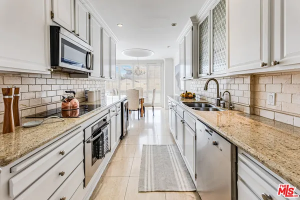 a kitchen with stainless steel appliances granite countertop a sink stove and cabinets
