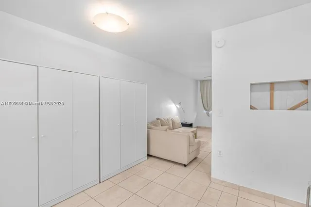 a room with a bed and a lamp on a dresser