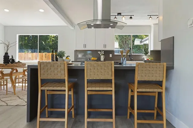 a large kitchen with stainless steel appliances granite countertop a lot of counter space and wooden floors