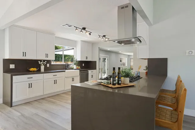 a kitchen with stainless steel appliances granite countertop a stove a sink and a refrigerator