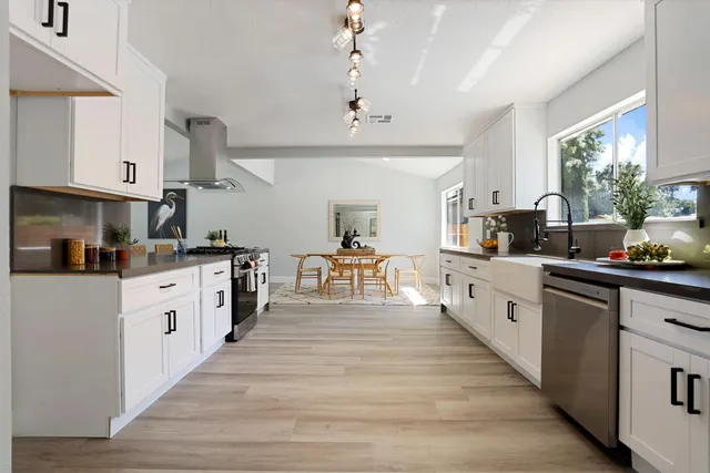 a kitchen with granite countertop white cabinets and white appliances