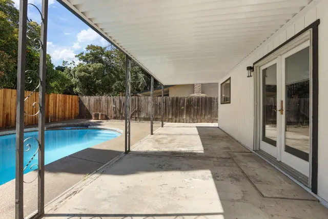 a view of a house with backyard and trees