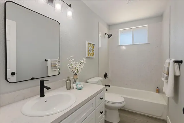a living room with furniture potted plant kitchen view and a window
