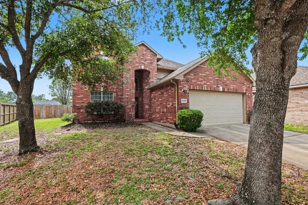 a view of a house with a tree in the yard