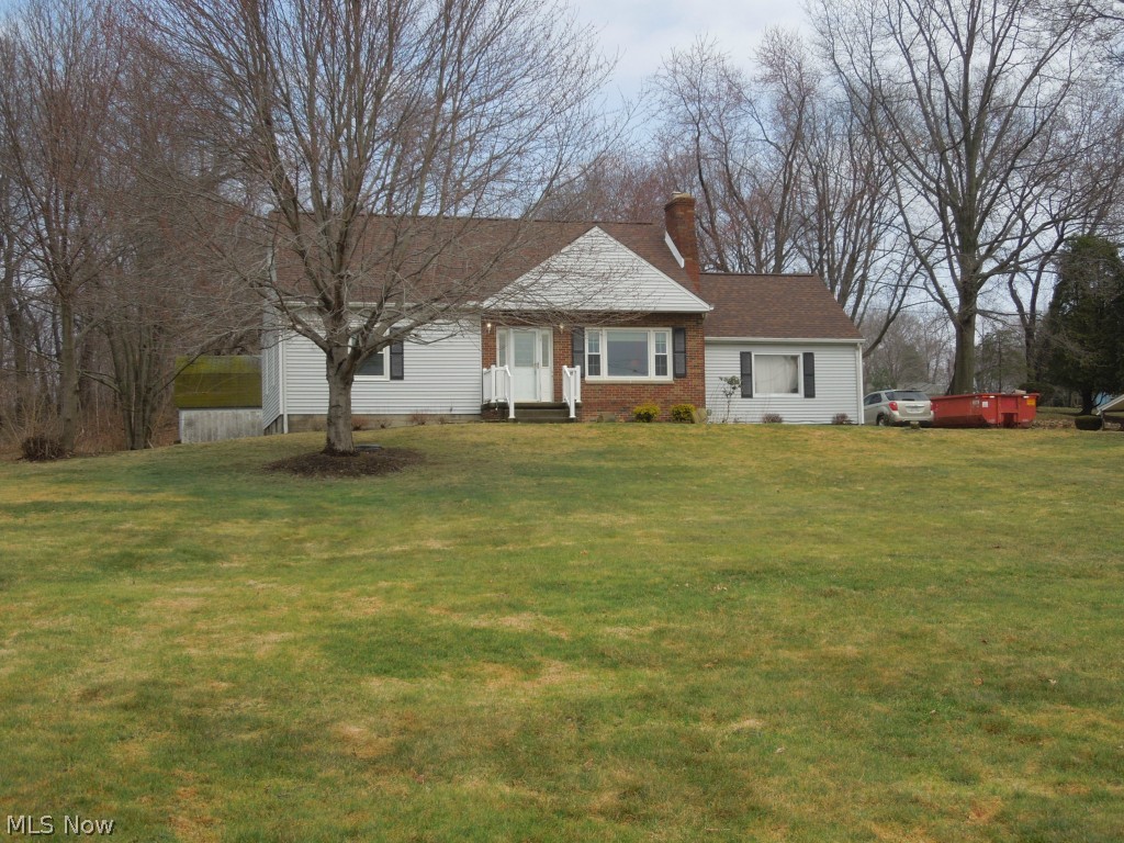 1057 Waterloo Road Mogadore, OH 44260 - Photo 14 of 14 Another view of the front of the house, dumpster on right side will be removed. Two car attached garage is to the right of the house near the cars.