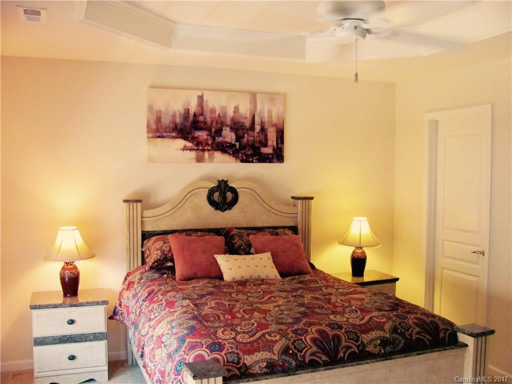 1068 Drayton Court, Unit 100 Fort Mill, SC 29708 - Photo 9 of 15 a bedroom with a bed and a lamp with the wall painting