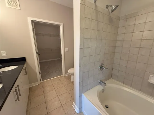 an empty room with a chandelier fan and closet