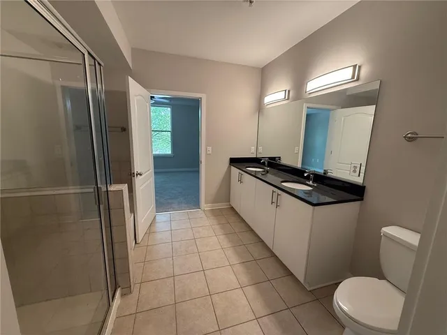 a large bathroom with a double vanity sink toilet and shower