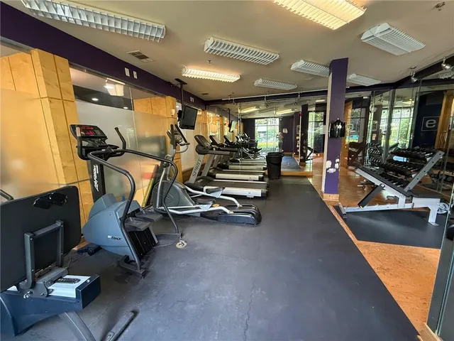 a living room with furniture gym equipment and a large window