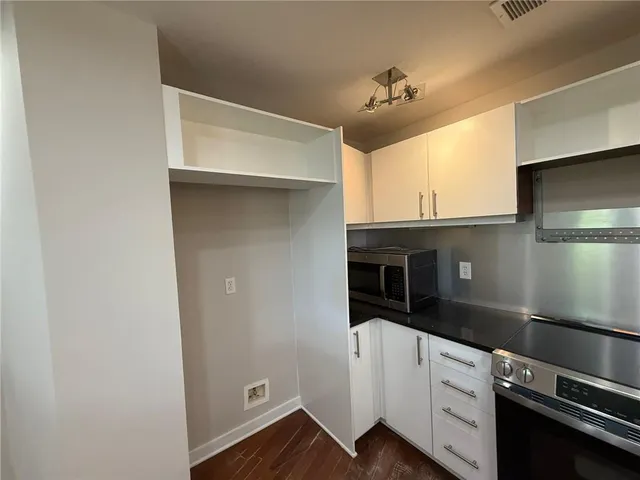 a kitchen with granite countertop white cabinets and a stove