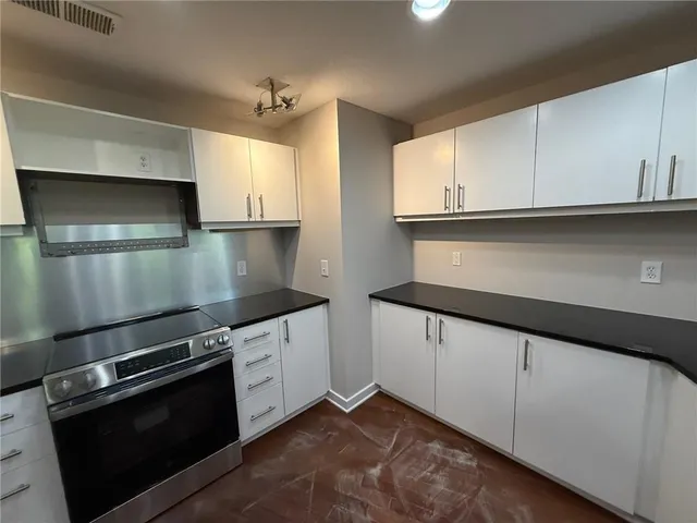 a kitchen with granite countertop white cabinets and a sink