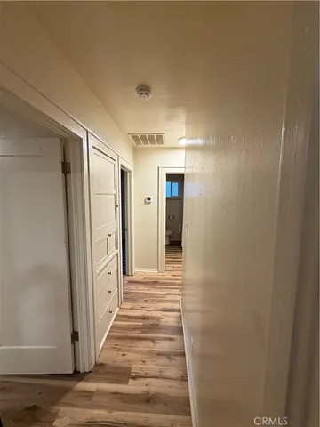 a view of a hallway with wooden floor and staircase