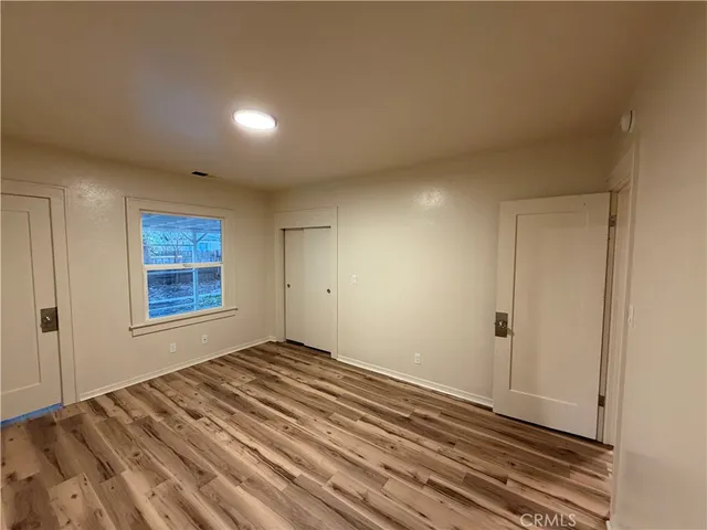 a view of a room with wooden floor and window