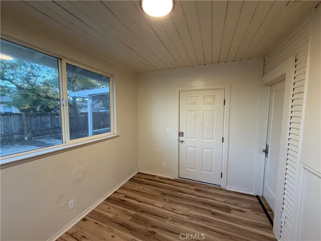 a view of a room with wooden floor and small window
