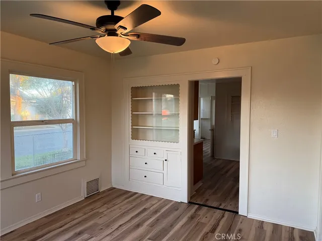 a view of an empty room with a window and wooden floor