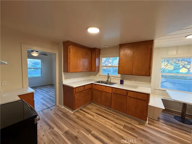 a large kitchen with wooden floor and stainless steel appliances