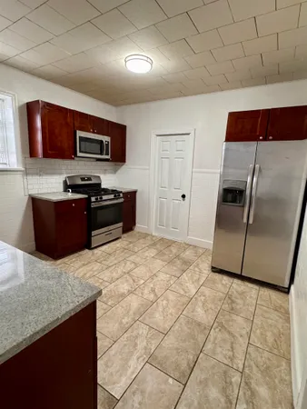 a kitchen with stainless steel appliances granite countertop a refrigerator and a sink