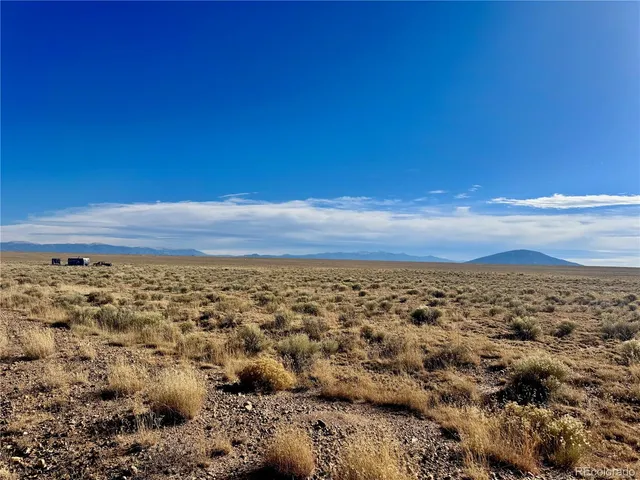 an aerial view of house with yard and mountain view in back