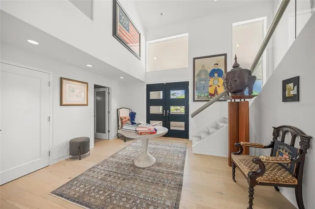 a living room with stainless steel appliances furniture a rug and a kitchen view