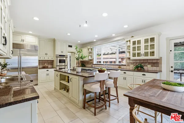 a kitchen with appliances a sink and cabinets