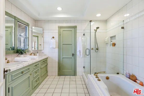 a bathroom with a tub sink and mirror
