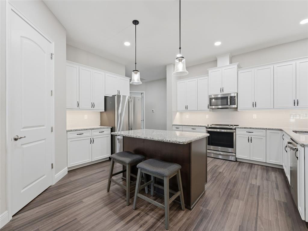 4025 Spring Park Way Brooksville, FL 34604 - Photo 16 of 97 a kitchen with stainless steel appliances granite countertop a table chairs stove a sink dishwasher a refrigerator and cabinets with wooden floor