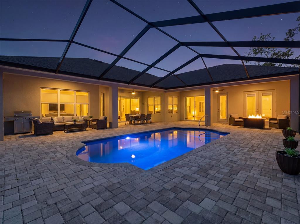 4025 Spring Park Way Brooksville, FL 34604 - Photo 2 of 97 a swimming pool with lawn chairs under an umbrella
