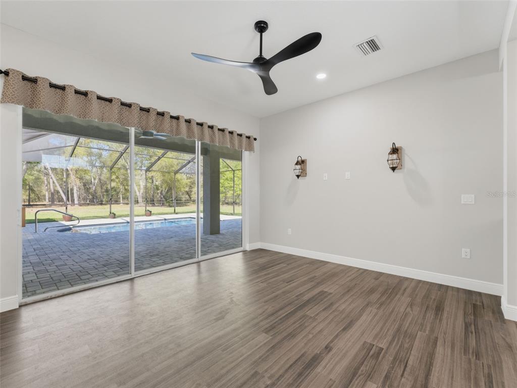 4025 Spring Park Way Brooksville, FL 34604 - Photo 31 of 97 an empty room with wooden floor and windows