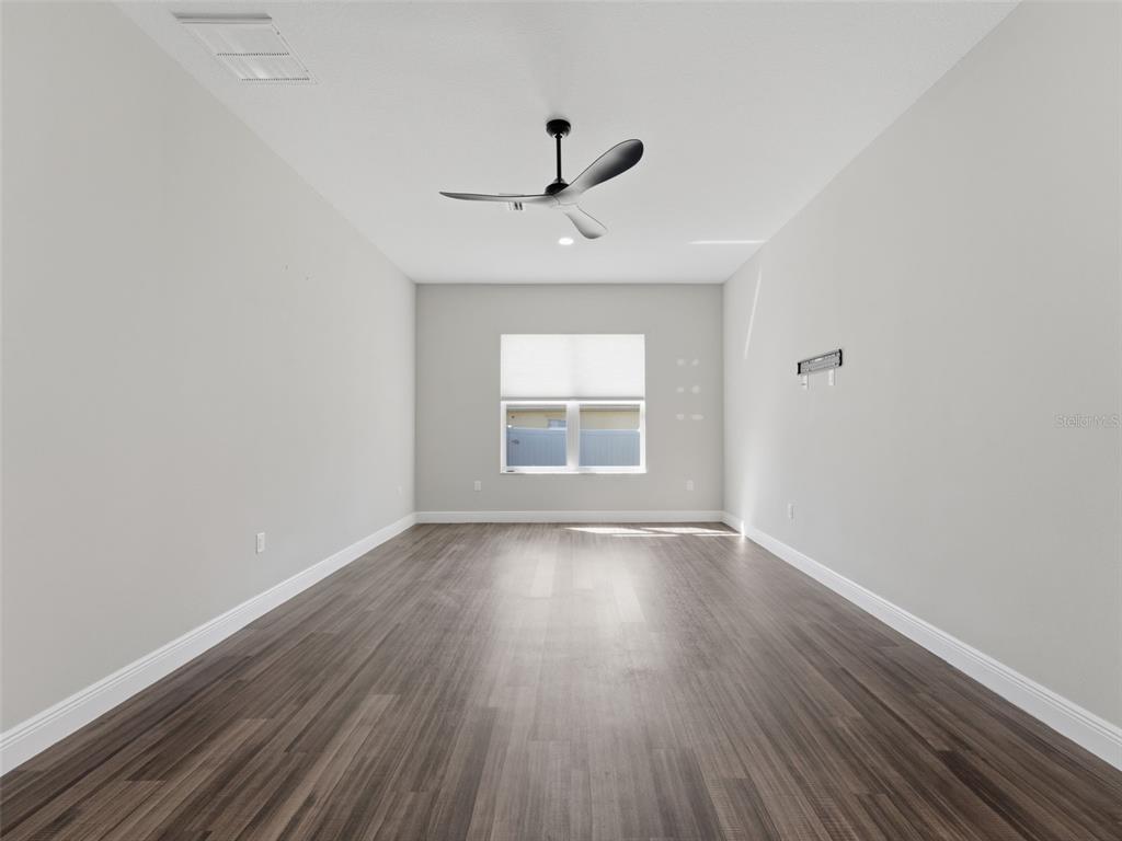 4025 Spring Park Way Brooksville, FL 34604 - Photo 56 of 97 wooden floor in an empty room with a window