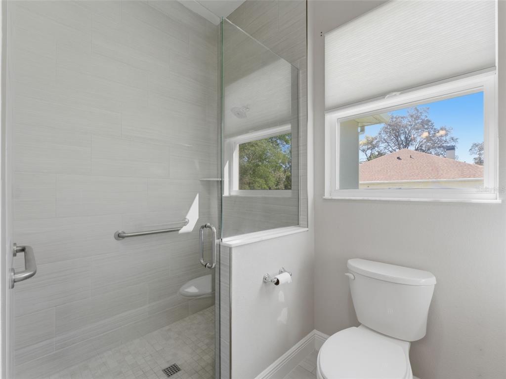4025 Spring Park Way Brooksville, FL 34604 - Photo 60 of 97 a white toilet sitting next to a bathroom sink and tub