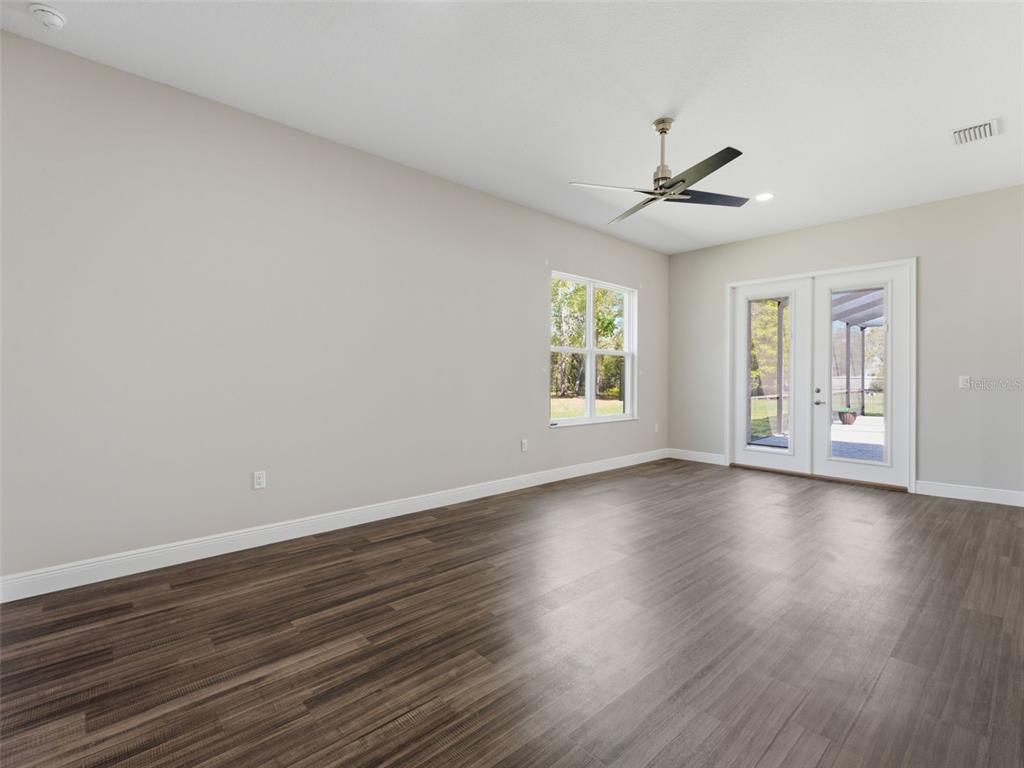 4025 Spring Park Way Brooksville, FL 34604 - Photo 66 of 97 an empty room with wooden floor ceiling fan and windows