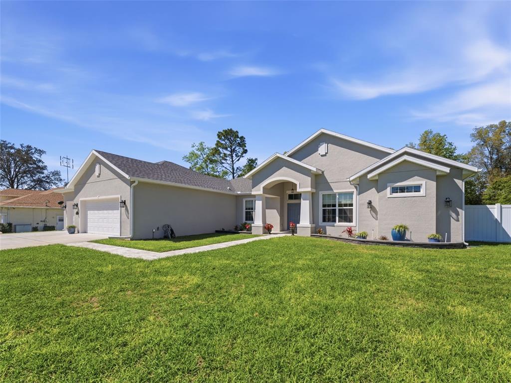 4025 Spring Park Way Brooksville, FL 34604 - Photo 7 of 97 a front view of a house with a yard and garage