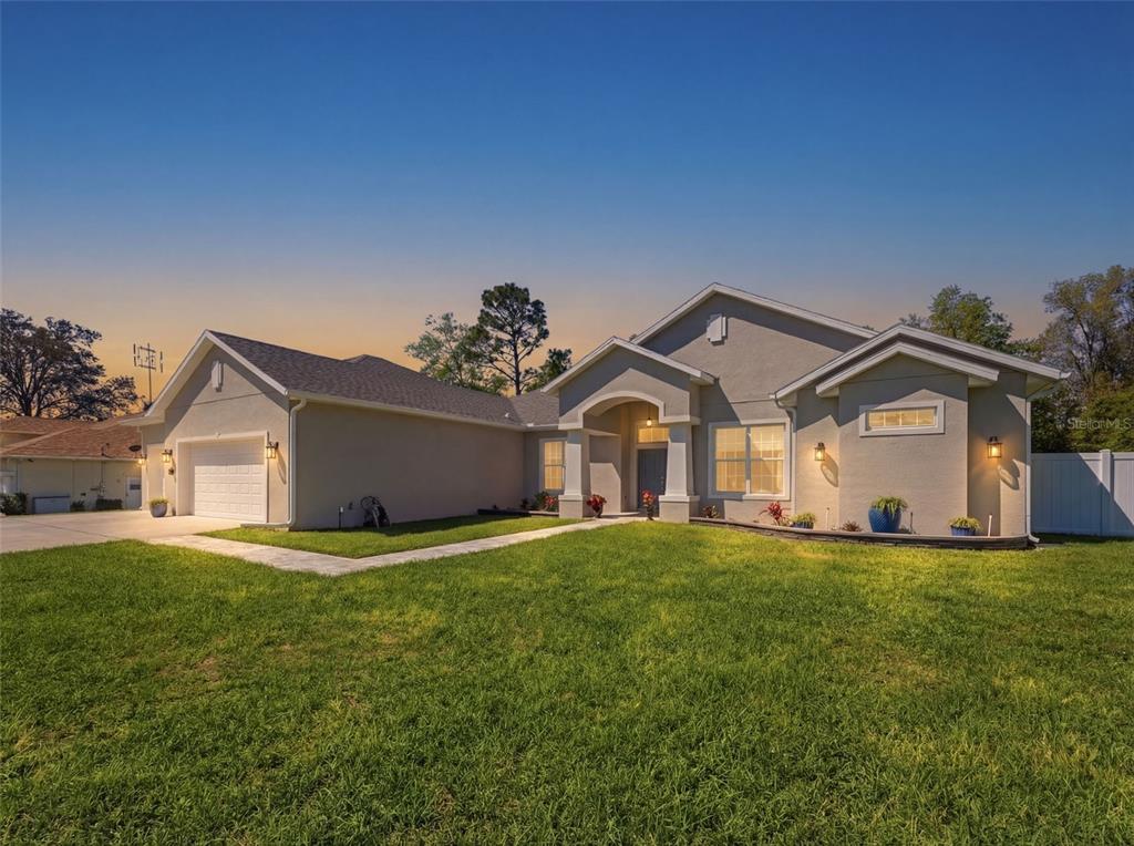 4025 Spring Park Way Brooksville, FL 34604 - Photo 96 of 97 a front view of a house with a yard and garage