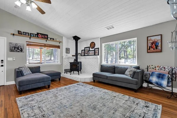 a open kitchen with stainless steel appliances granite countertop a stove top oven a refrigerator a dining table and chairs with wooden floor