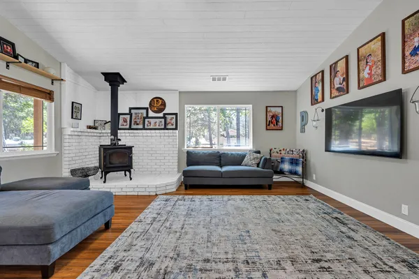 a living room with furniture a window and wooden floor