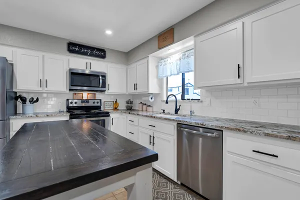 a bathroom with a granite countertop toilet and a sink