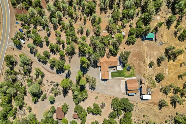 an aerial view of a house with a yard and sitting area