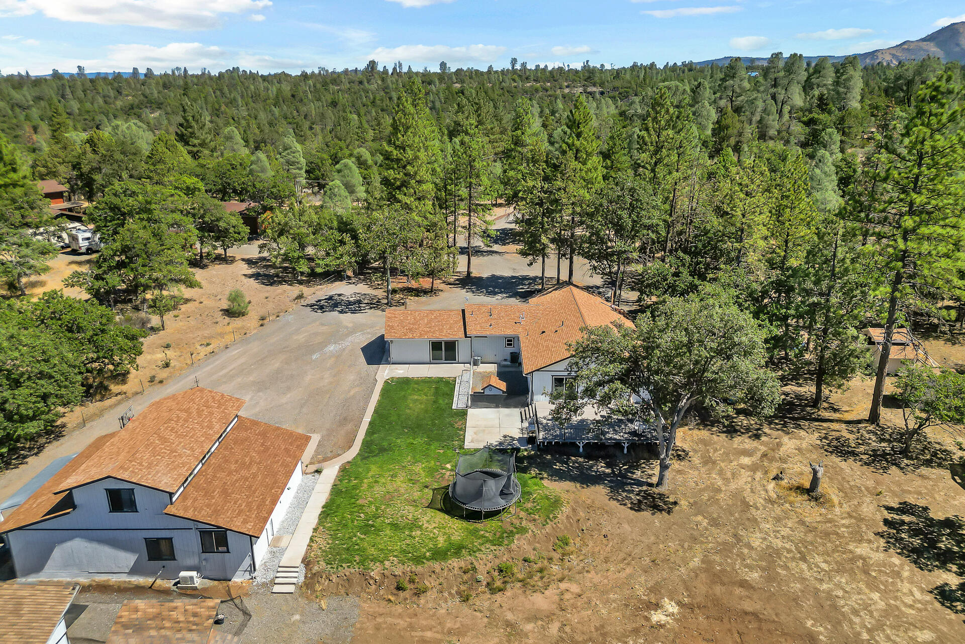 23570 Cassel Fall River Road Fall River Mills, CA 96028 - Photo 6 of 73 an aerial view of a house with yard swimming pool and mountain view