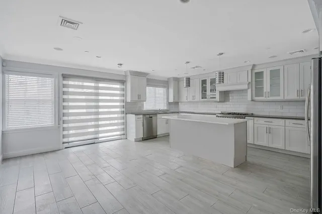 a kitchen with stainless steel appliances cabinets and a window