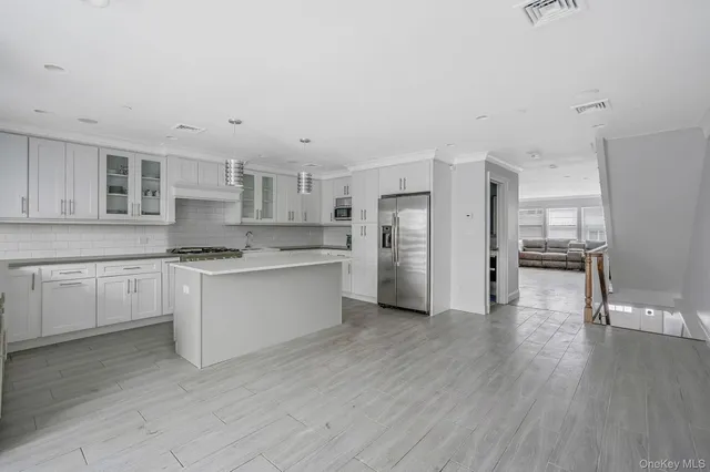 a kitchen with stainless steel appliances a refrigerator sink and cabinets